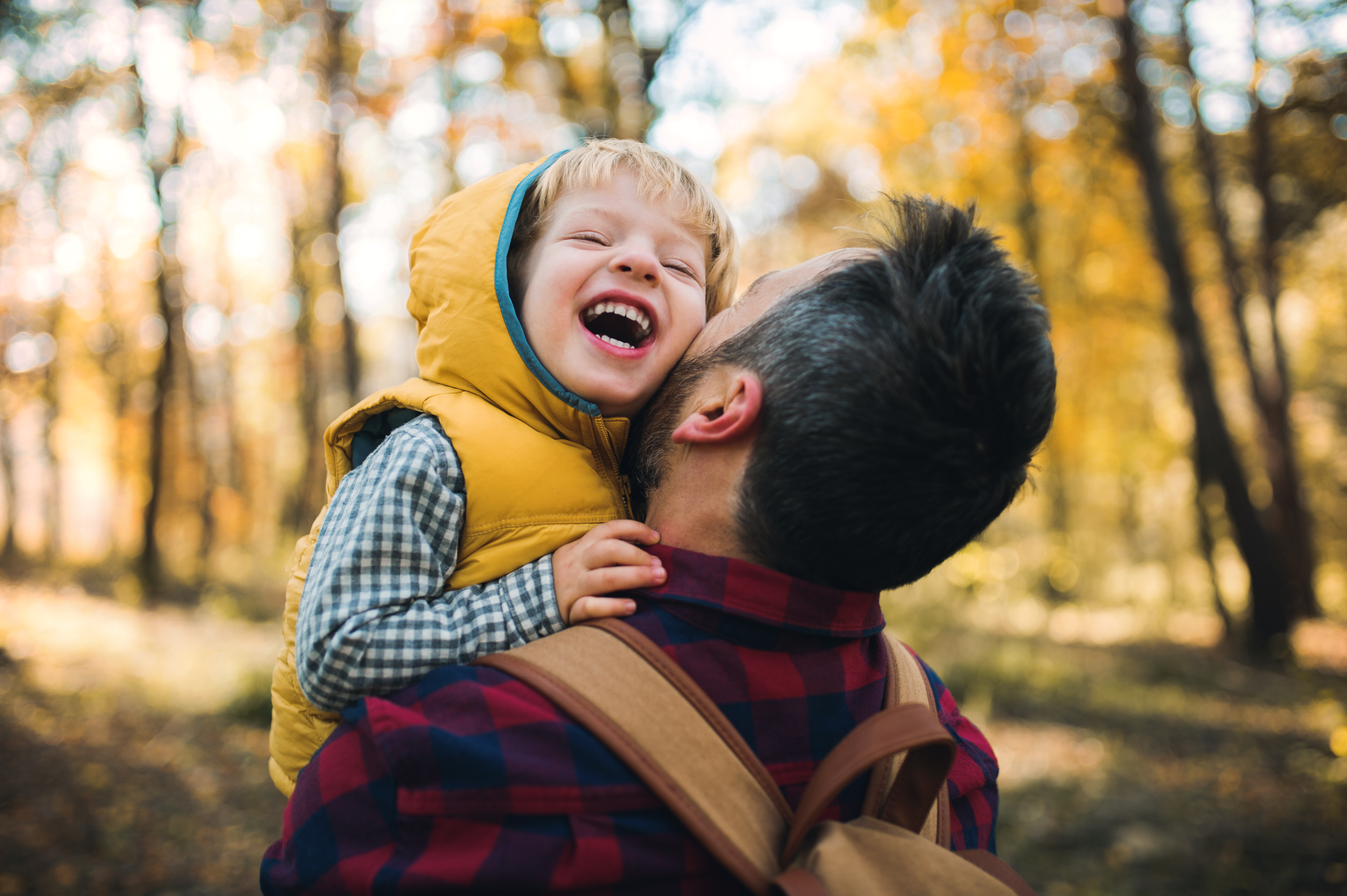 Child and father laughing in forest